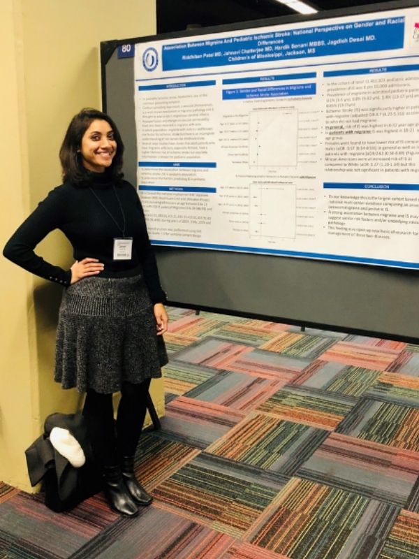 Student stands with her poster presentation.